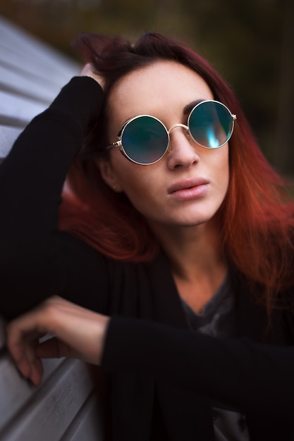 Schöne rote Haarfrau in der Sonnenbrille