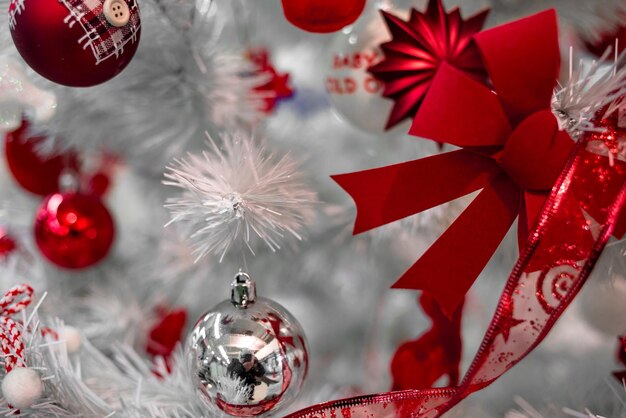 Schöne rote und silberne Weihnachtsbälle auf einem weißen Weihnachtenbaum mit Dekorationen
