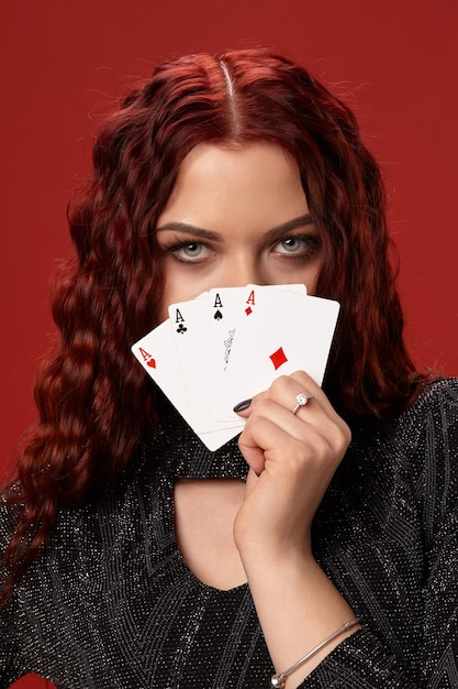 Schöne rothaarige Frau hält einige Spielkarten Casino