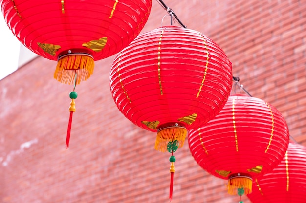 Schöne runde rote Laterne, die an der alten traditionellen Straße, Konzept des chinesischen Mondneujahrsfestes, nah oben hängt. Das zugrunde liegende Wort bedeutet Segen.