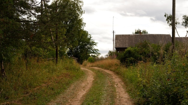 Schöne rustikale Sommerlandschaft mit Straße Alte Holzblockhäuser Region Wologda