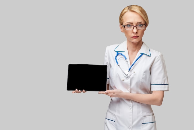 Schöne Ärztin, die Tablette PC-Pad isoliert hält