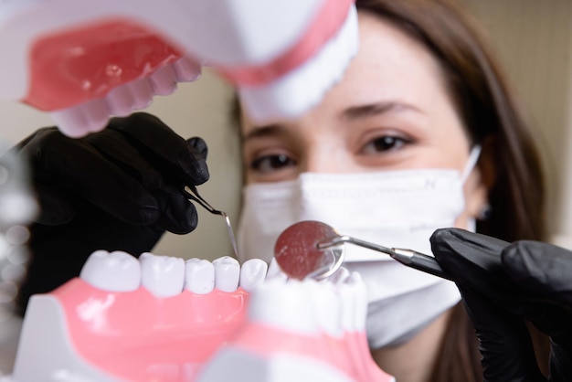 schöne Ärztin mit zahnmedizinischer Ausrüstung in der Zahnheilkunde