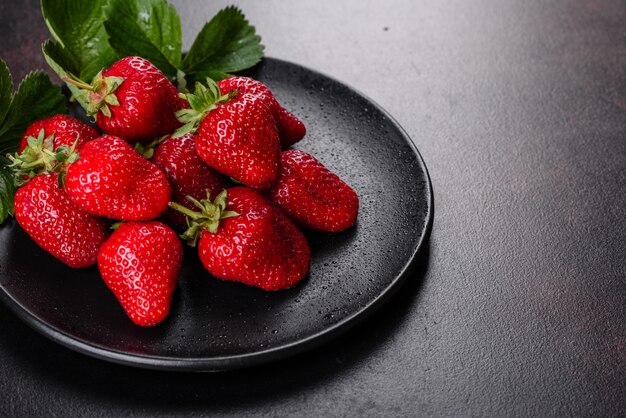 Schöne saftige frische Erdbeeren auf der Betonoberfläche des Tisches