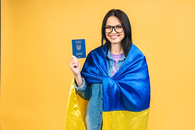 Schöne, schöne, fröhliche, fröhliche Frau, die den ukrainischen Pass und die ukrainische Flagge in den Händen hält