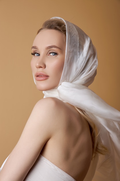 Schöne Schönheit blonde Frau mit einem großen weißen Kopftuch, weißes Tuch
