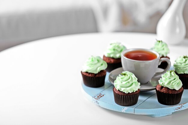 Schöne Schokoladencupcakes und eine Tasse Tee auf dem Tisch