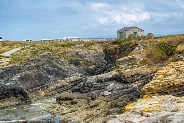 Schöne schroffe Aussicht auf die Küste Galiziens mit dem Meer, das mit Moos und Flechten in die Felsen eindringt