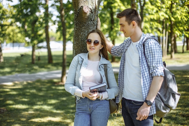 Schöne Schüler. Paare von den reizenden Studenten, die nach der Schule stillstehen.