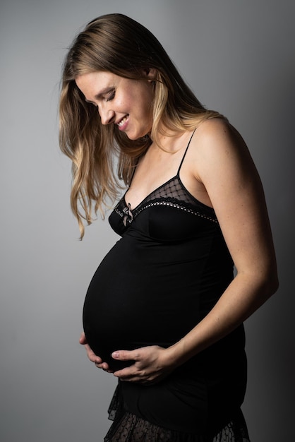 Schöne schwangere Frau auf dunklem Hintergrund