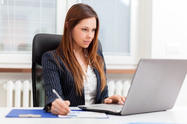 Schöne Sekretärin bei der Arbeit in ihrem Büro