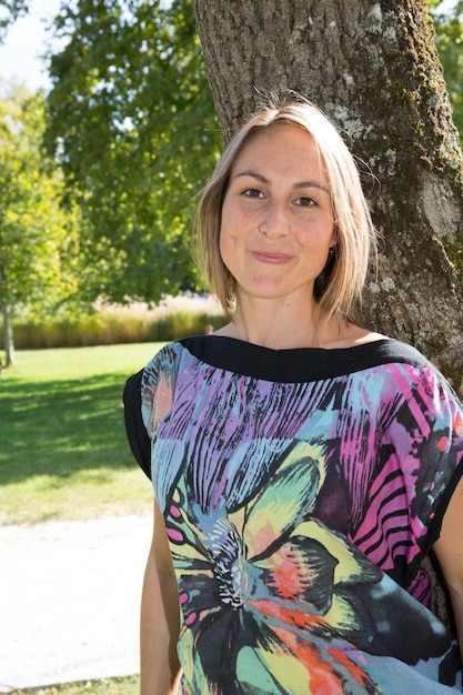 Schöne selbstbewusste junge Frau des Porträts am sonnigen Parksommertag