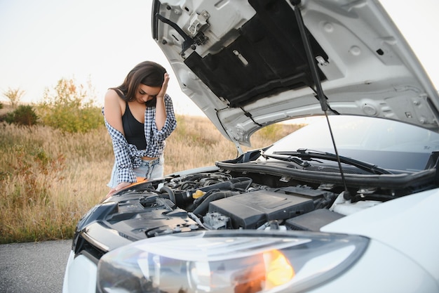 Foto schöne sexy frau in der nähe eines kaputten autos verwirrte frau weiß nicht, was sie tun soll