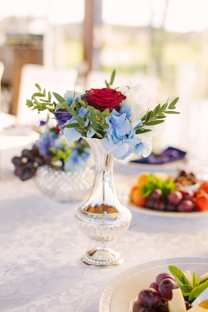 Schöne silberne Vase mit einem Blumenstrauß im Dekor