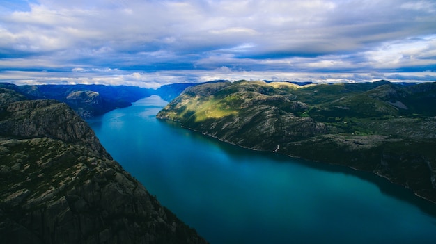 Schöne Sommer lebendige Aussicht auf berühmten norwegischen touristischen Ort - Trolltunga, die Trolle Zunge mit einem See und Berge, Norwegen, Odda.