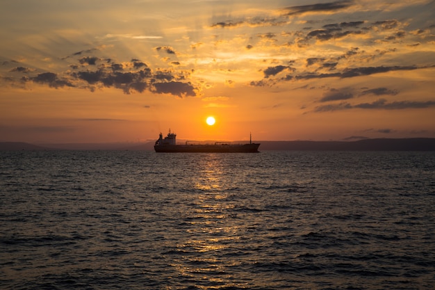 Schöne Sonnenuntergangansicht über das See- und Schiffsschattenbild in der Mitte