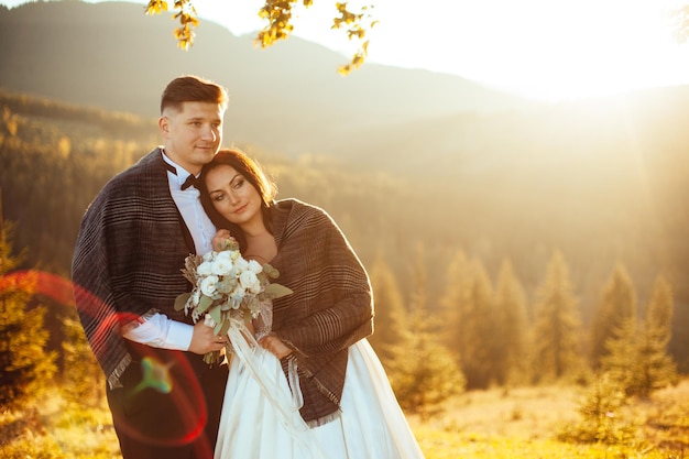 Schöne Sonnenuntergangs-Hochzeits-Braut und Bräutigam bei Sonnenuntergang