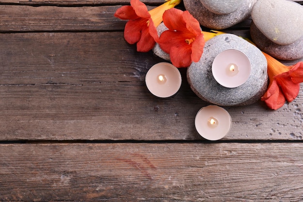 Schöne Spa-Komposition mit Kerzen und Blumen auf einem Holztisch aus der Nähe