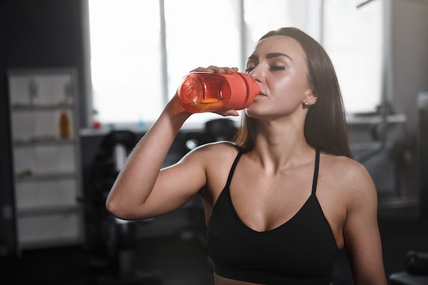 Schöne Sportlerin Trinkwasser nach dem Training