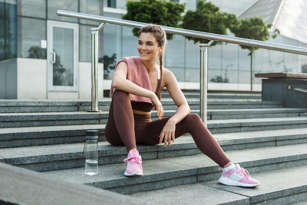 Schöne sportliche Frau nach Fitness- oder Jogging-Training auf einer Stadtstraße