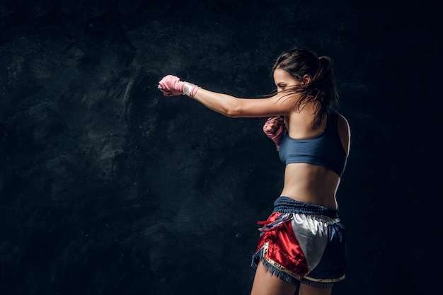 Schöne sportliche Frau wärmt sich vor dem Training auf, während sie für Fotografen posiert.