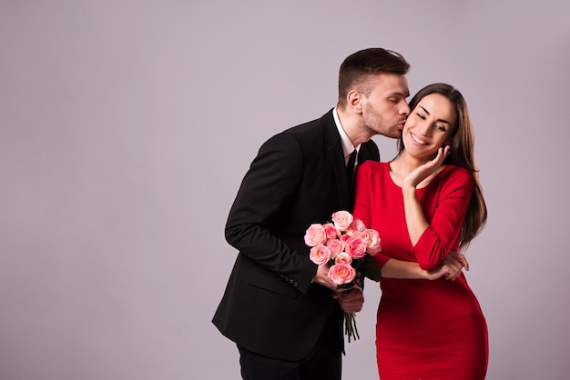 Schöne stilvolle und elegante Paare in Anzug und Kleid umarmen sich, haben Spaß und posieren isoliert im Studio. Feiertage und Veranstaltungen. Valentinstag. Tag der Liebenden