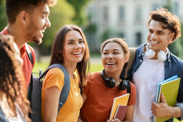 Schöne Studentin geht mit College-Freunden im Freien spazieren