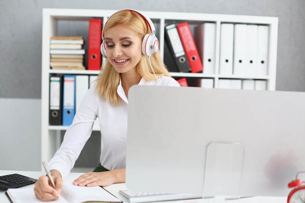 Schöne studentin mit kopfhörern, die musik hören