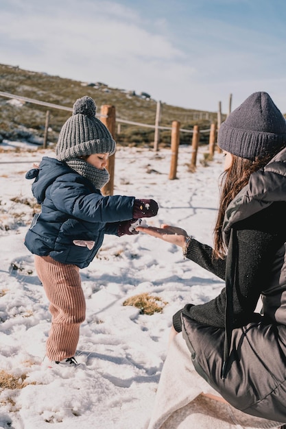 Foto schöne szene einer mutter und tochter, die an einem sonnigen tag den schnee genießen