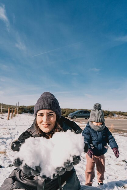 Foto schöne szene einer mutter und tochter, die an einem sonnigen tag den schnee genießen