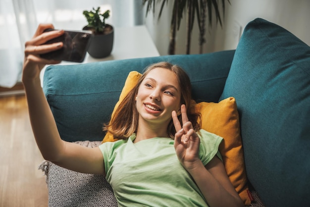 Schöne Teenager-Mädchen machen Selfie mit Smartphone, während sie Freizeit bei sich zu Hause haben.