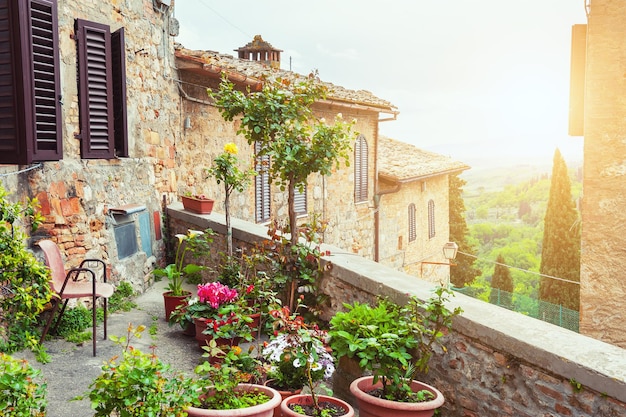 Schöne Terrasse mit Blumen. Alte Architektur in San Gimignano, Toskana, Italien.