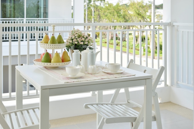 Schöne Terrasse mit weißen Möbeln und Tee oder Kaffee zu Hause