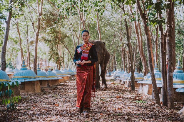 Schöne thailändische Frau, die Zeit mit dem Elefanten im Dschungel verbringt