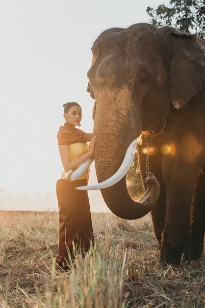 Schöne thailändische Frau, die Zeit mit dem Elefanten im Dschungel verbringt