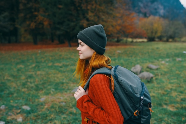 Schöne Touristin mit Rucksack spaziert im Park in der Natur