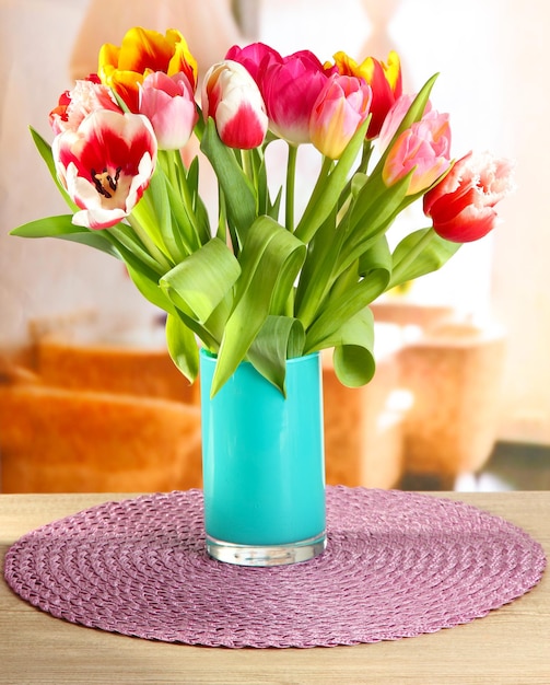 Schöne Tulpen im Eimer auf dem Tisch im Zimmer