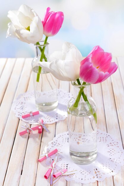 Schöne Tulpen im Eimer in der Vase auf dem Tisch auf hellem Hintergrund