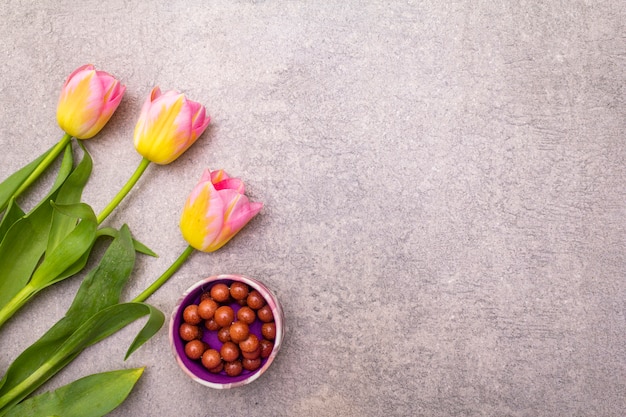 Schöne Tulpen und Perlen in einer Schüssel