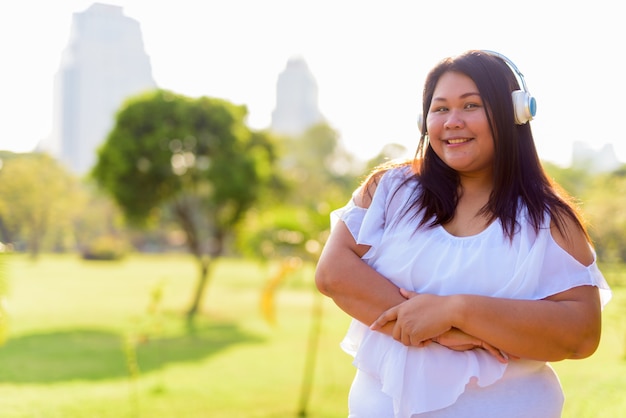 Schöne übergewichtige asiatische Frau, die am Park entspannt