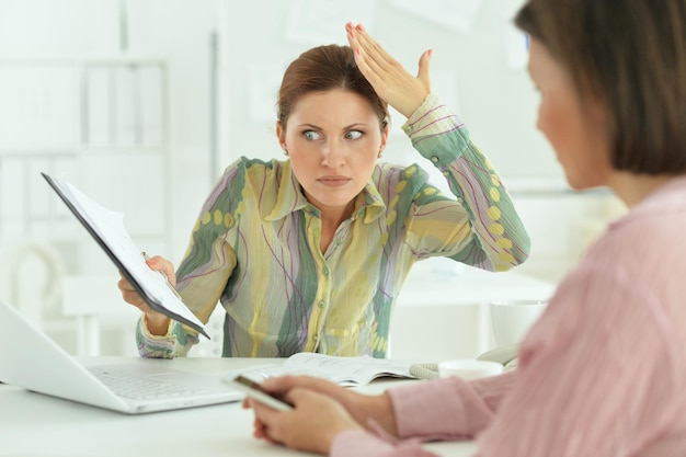 Foto schöne und emotionale geschäftsfrauen, die in einem modernen büro arbeiten