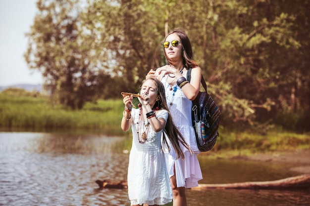 Schöne und glückliche junge Mutter und kleine Tochter an einem hellen sonnigen Tag der Natur zusammen