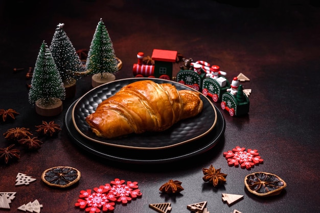 Schöne verschiedene Weihnachtsdekorationen und Croissants auf einem braunen Betontisch