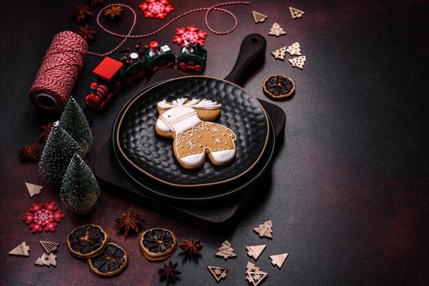 Schöne verschiedene Weihnachtsdekorationen und Lebkuchen auf einem braunen Betontisch