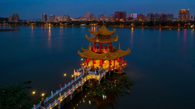 Schöne verzierte Pagode des traditionellen Chinesen mit Kaohsiung-Stadt im Hintergrund nachts, Wuliting, Kaohsiung, Taiwan.