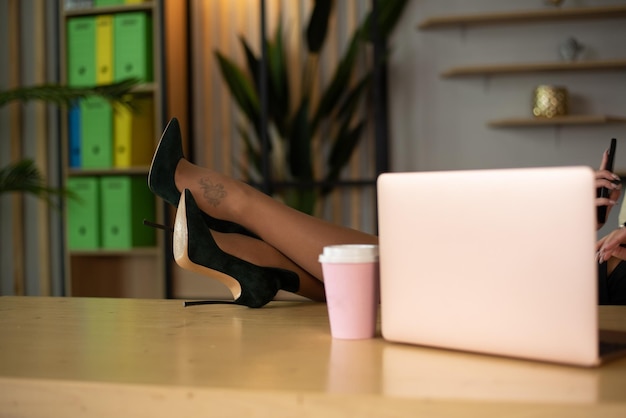 Schöne weibliche Füße liegen auf dem Schreibtisch Nicht erkennbares Foto Frauenfüße auf dem Tisch Kopie des Raums Draufsicht