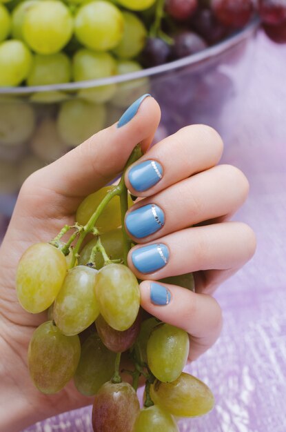 Schöne weibliche Hand mit blauem Nageldesign.