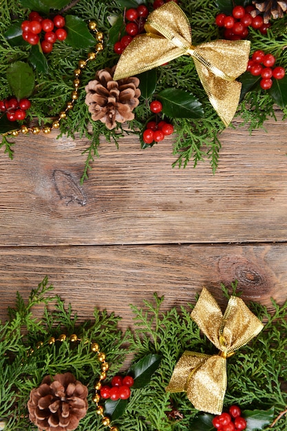 Schöne Weihnachtsgrenze aus Tanne und Mistel auf Holzuntergrund