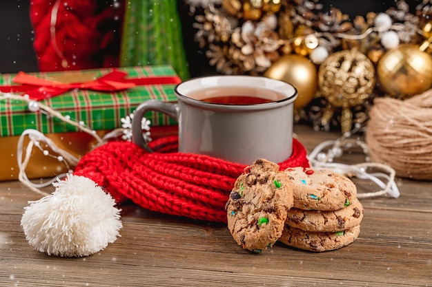 Schöne Weihnachtskarte mit einer Tasse Tee und Keksen gemütlicher Weihnachtsdekor auf dunklem Hintergrund