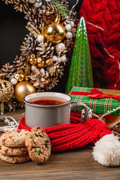 Schöne Weihnachtskarte mit einer Tasse Tee und Keksen gemütlicher Weihnachtsdekor auf dunklem Hintergrund